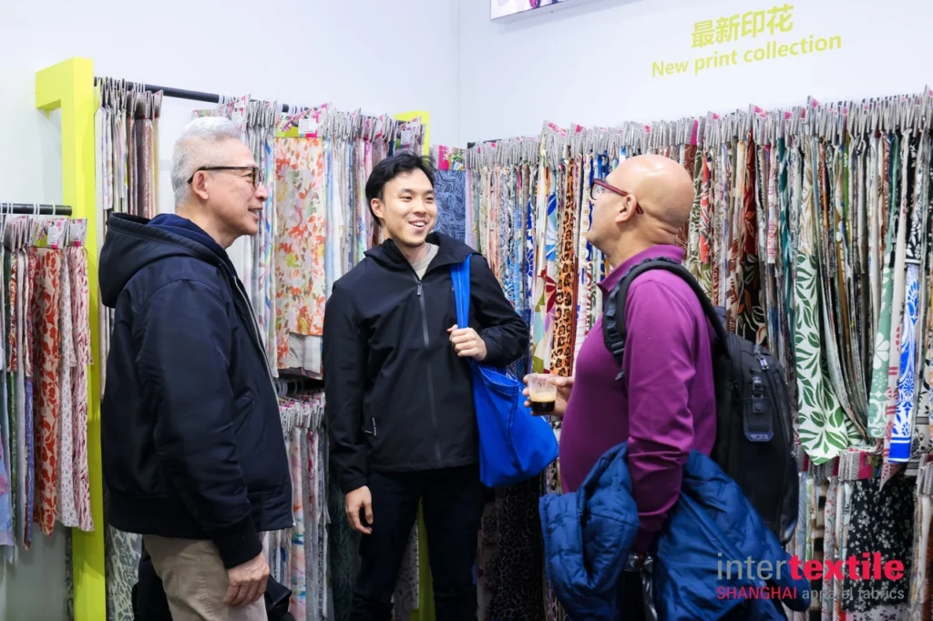 algo bert fashion intertextile shanghai buyer meeting - business discussion between foreign buyer and Chinese supplier at exhibition booth